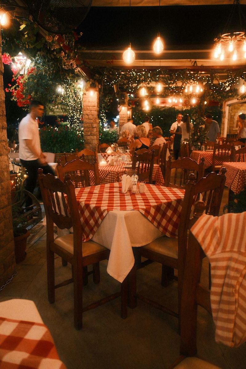 La sala apparecchiata con le tovaglie a quadri, di sera